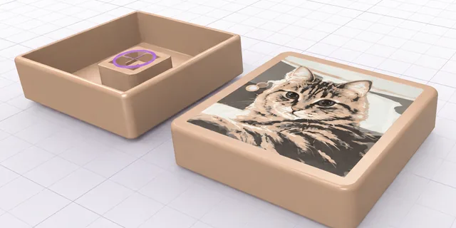 A 3D printed clicker with a cat picture on top, made with Clicker Wonderland